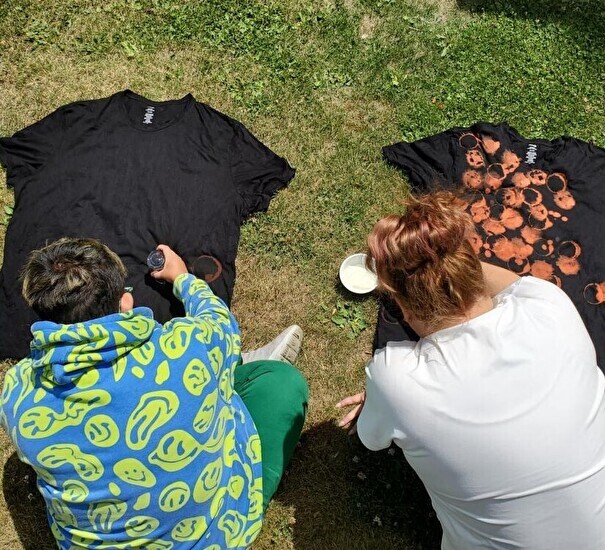 two people painting a t-shirt