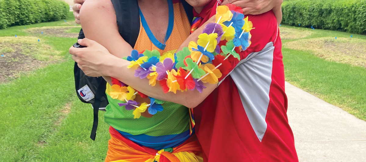 two men in pride colours hugging