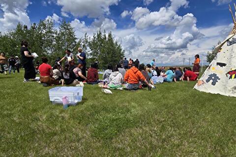 Image of group sitting on grass together