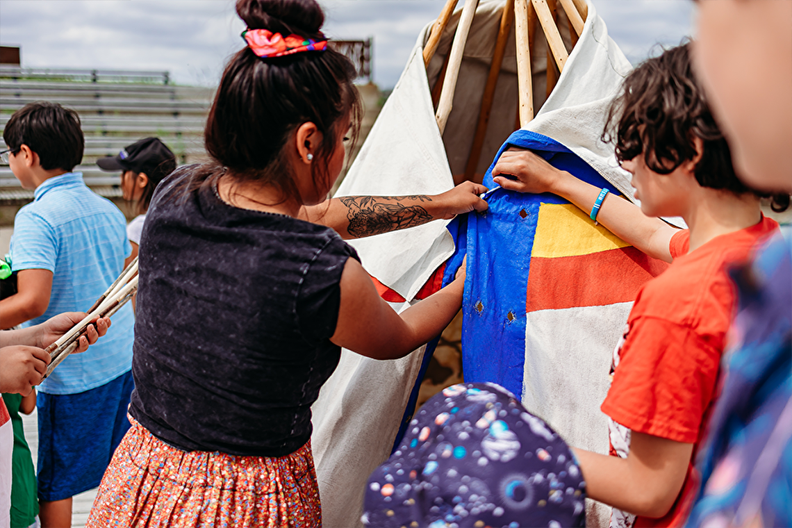 Family learning to build a teepee